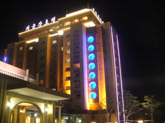 The Guemgangsan Hotel lit up at night, across from a village with no power The Guemgangsan Hotel lit up at night, across from a village with no power