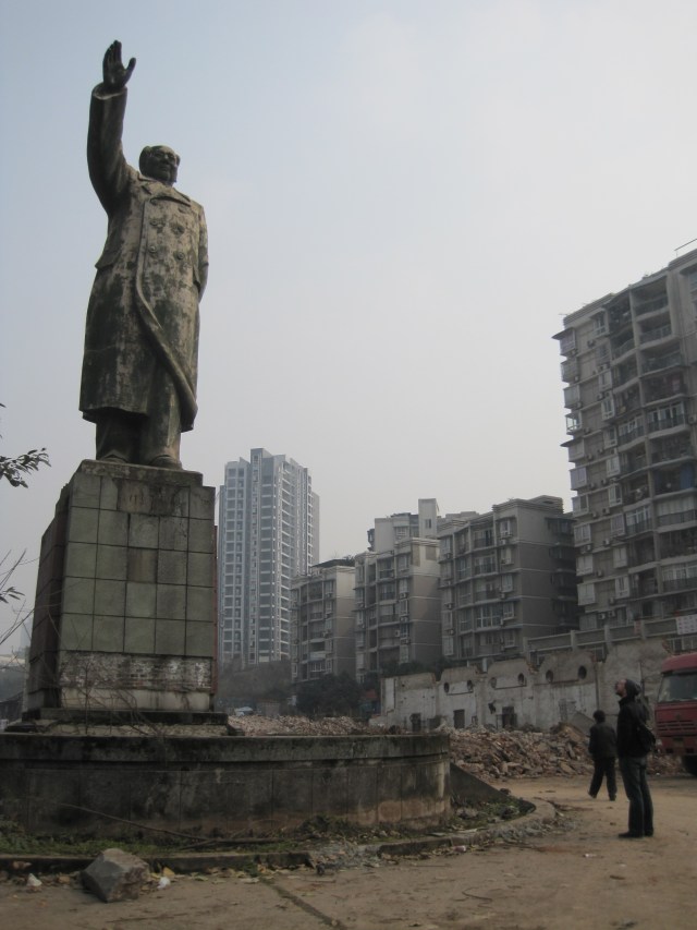 Shangqiao, Chongqing: A statue of Mao, the only thing left in a recently cleared plain of rubble, overlooks new construction projects 
